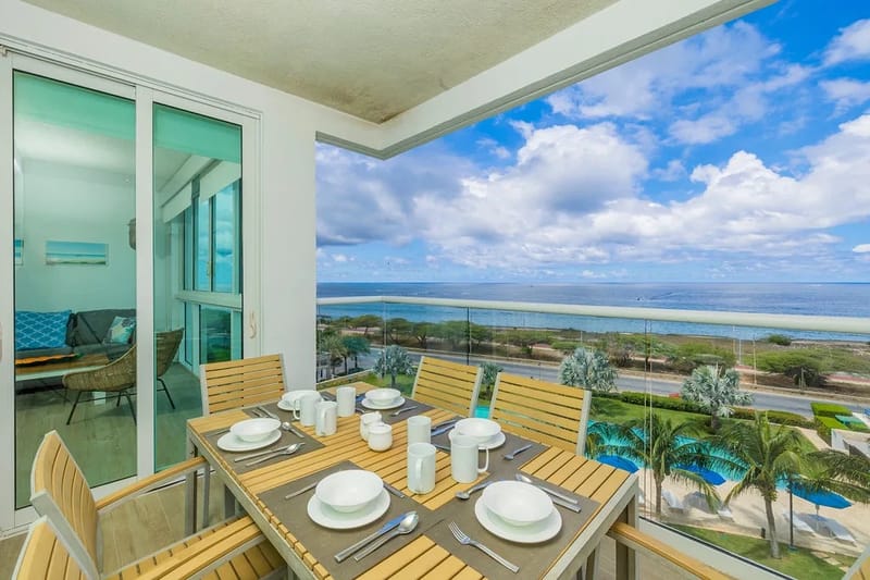 Mesa en el balcón privado con amplias vistas al mar y brisas tropicales.
