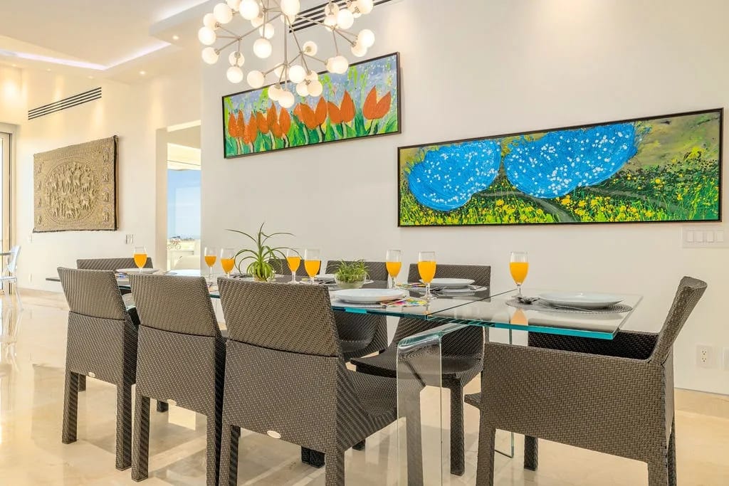 Reúnanse alrededor de esta elegante mesa de comedor, donde las coloridas obras de arte y la iluminación moderna crean el entorno perfecto para disfrutar juntos de comidas memorables.