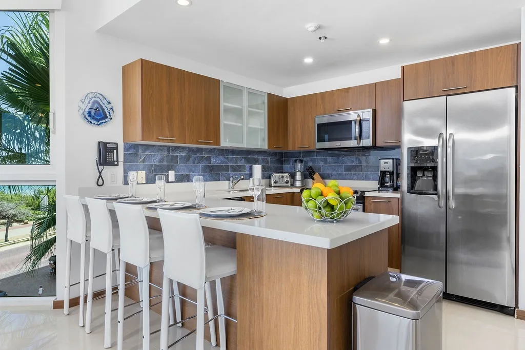 Fully equipped kitchen with modern appliances, sleek countertops, and a breakfast bar
