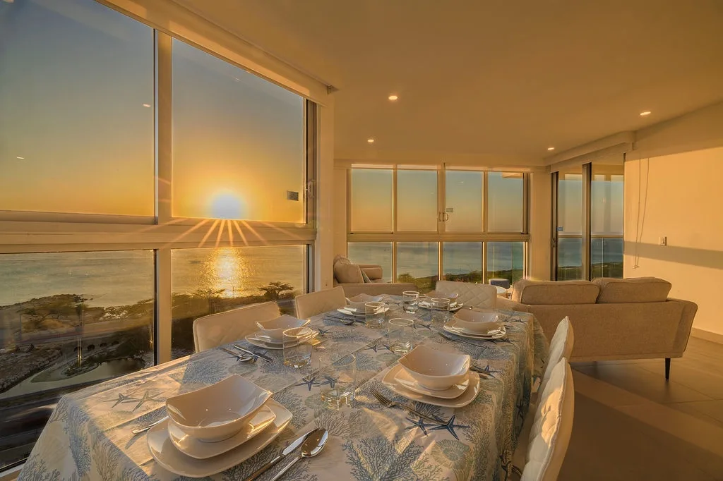 Comedor con ventanas de piso a techo y vistas al océano