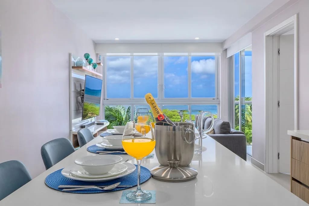 Un comedor luminoso y abierto enmarca impresionantes vistas al mar a través de ventanas de piso a techo.