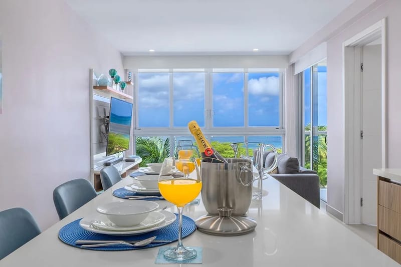 Un comedor luminoso y abierto enmarca impresionantes vistas al mar a través de ventanas de piso a techo.