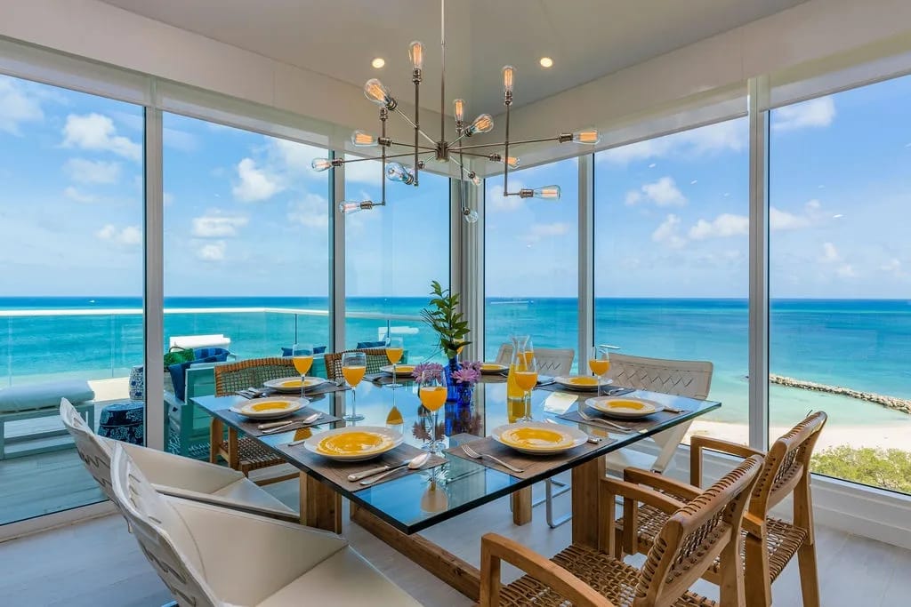 Picture yourself dining here, where every meal feels special against floor-to-ceiling ocean views and a stunning modern chandelier setting the perfect mood for memorable gatherings.