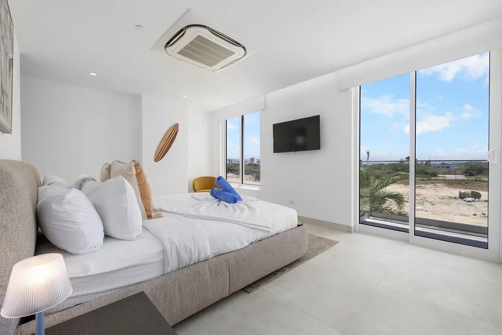 Relájese en su luminoso y moderno dormitorio, donde los ventanales panorámicos enmarcan impresionantes vistas de la costa. Le espera ropa de cama limpia, y el diseño espacioso crea un refugio tranquilo después de las aventuras en la playa.