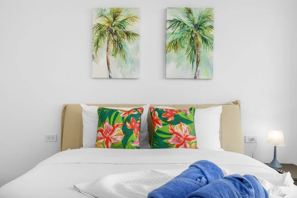 Sink into crisp white linens and vibrant tropical accents that bring island warmth right to your bedside. Your perfect retreat awaits.