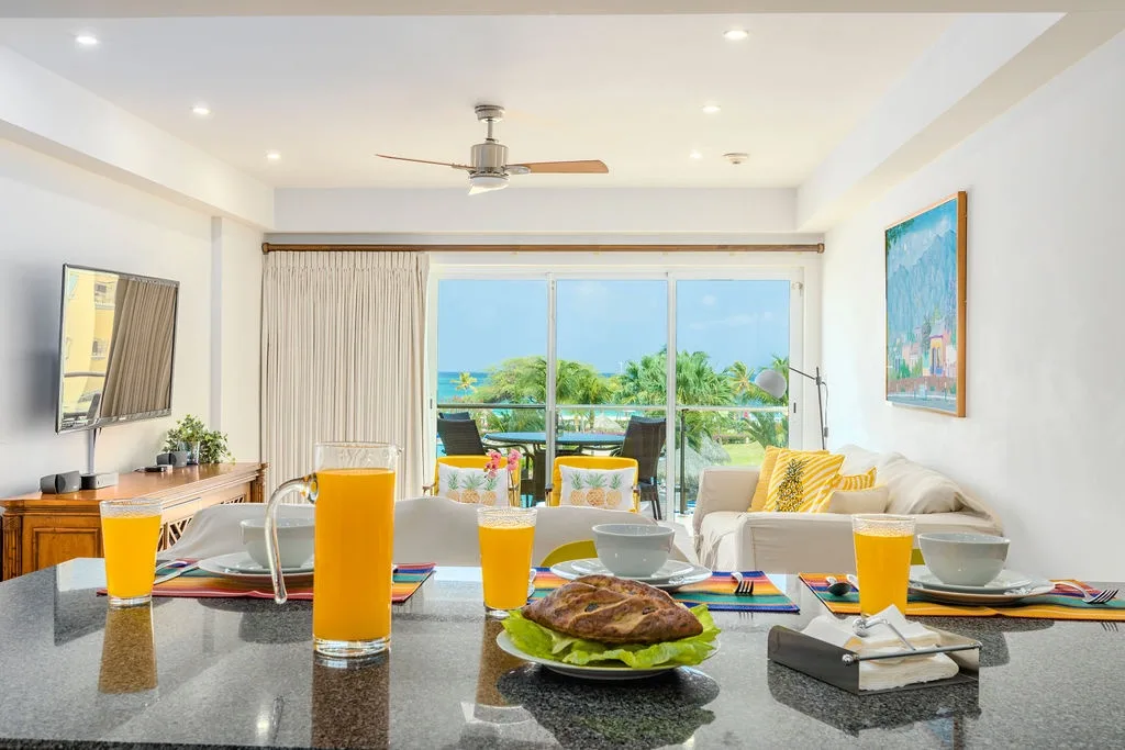 Imagínate comenzando el día con un jugo fresco y un desayuno en este espacio luminoso y abierto, donde circula la brisa del océano y las vistas tropicales enmarcan tu rutina matutina.