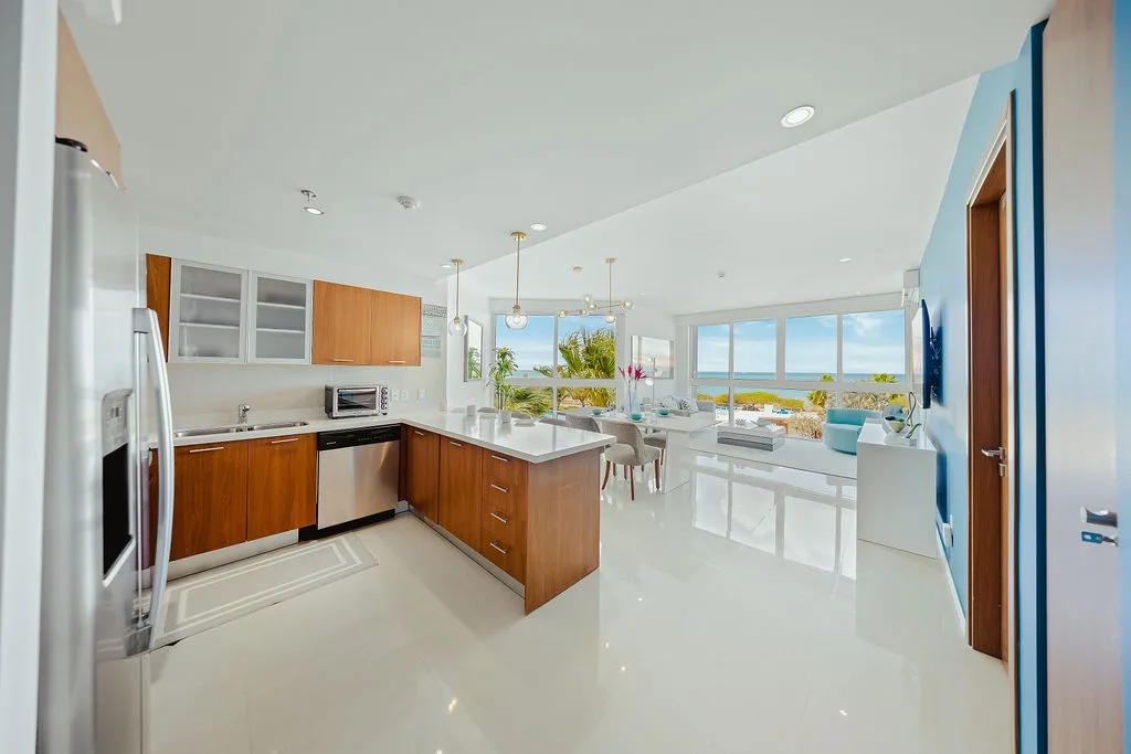 Su elegante cocina se integra a la perfección con la luminosa sala de estar, donde los ventanales de piso a techo enmarcan impresionantes vistas al mar.