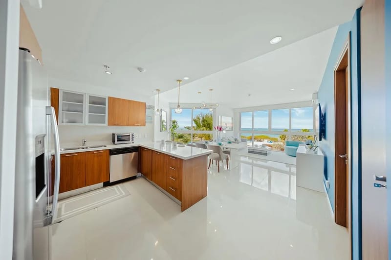 Su elegante cocina se integra a la perfección con la luminosa sala de estar, donde los ventanales de piso a techo enmarcan impresionantes vistas al mar.