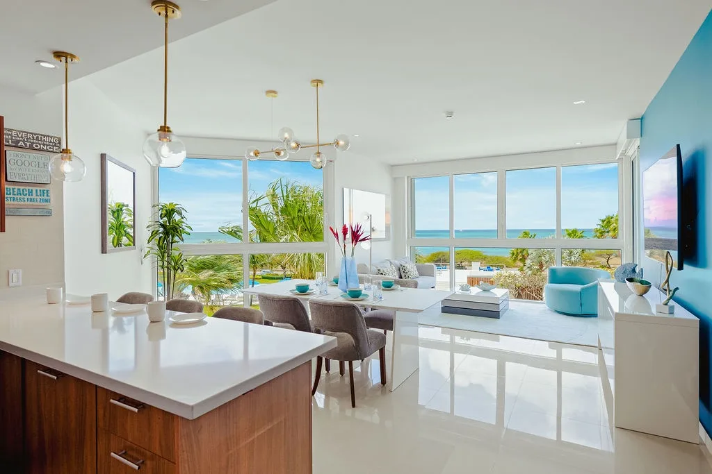 Relájese en su sala de estar luminosa y aireada, donde las impresionantes vistas al mar se extienden más allá de los ventanales de piso a techo, creando el refugio costero perfecto.