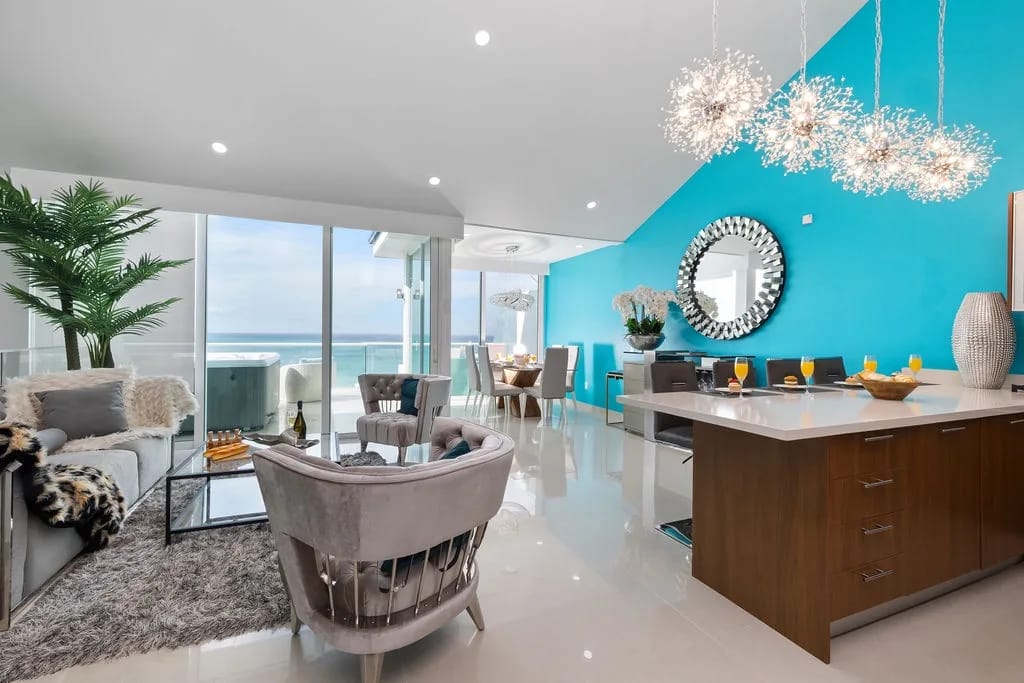 Impresionantes vistas al mar le dan la bienvenida desde este espacio moderno de concepto abierto, con una decoración elegante, accesorios relucientes y una transición fluida entre la sala de estar, el comedor y la cocina.