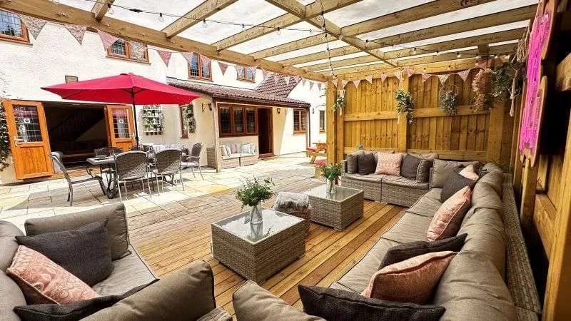 Bonita zona de estar cubierta con muebles de patio y vistas hacia la casa.