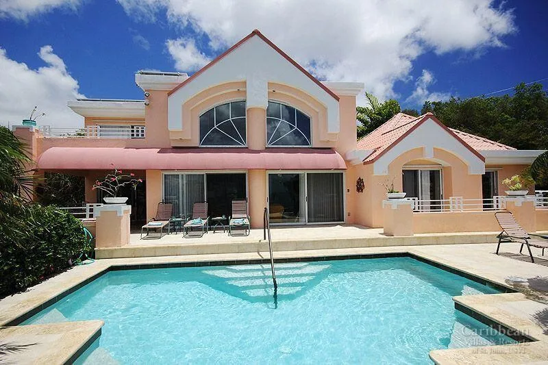 A large house faces a swimming pool, with a patio along the rear.