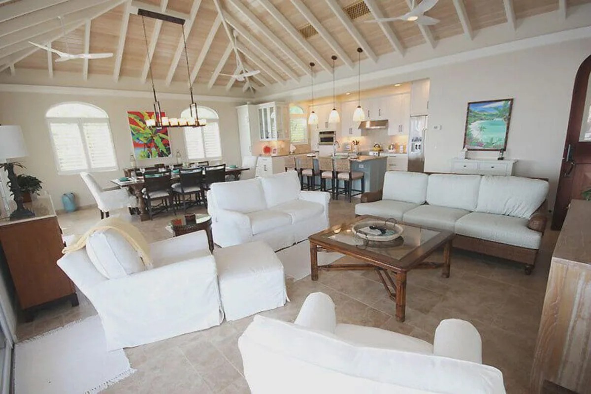 Salón de concepto abierto con sala de estar, cocina y mesa de comedor.