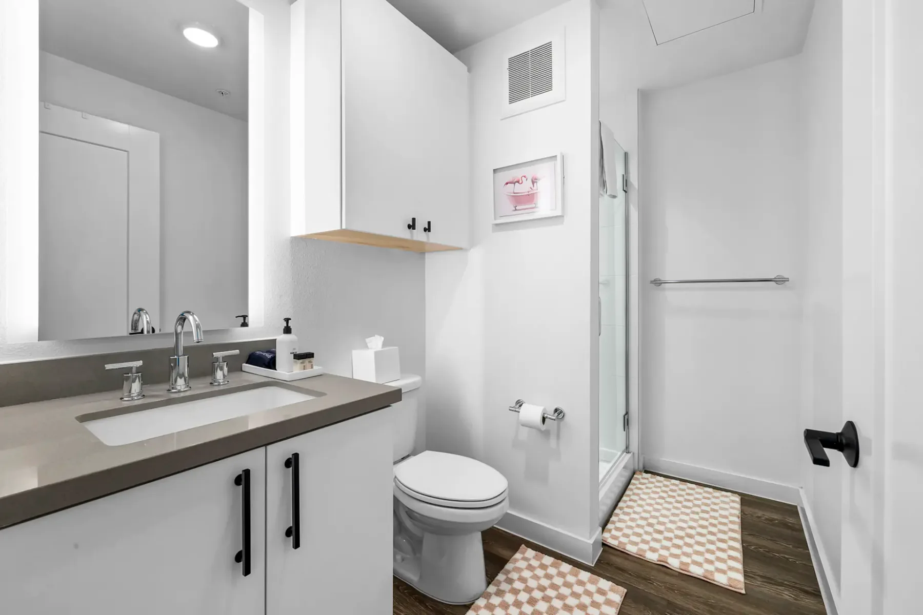 Baño moderno con lavabo, inodoro y ducha con cerramiento de vidrio.
