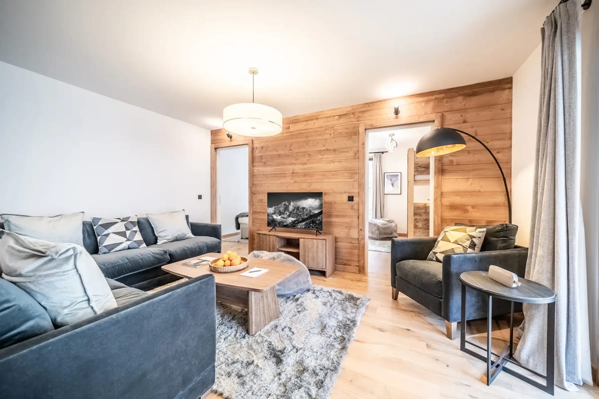 Modern living room with two sofas, a wooden coffee table, and a television.