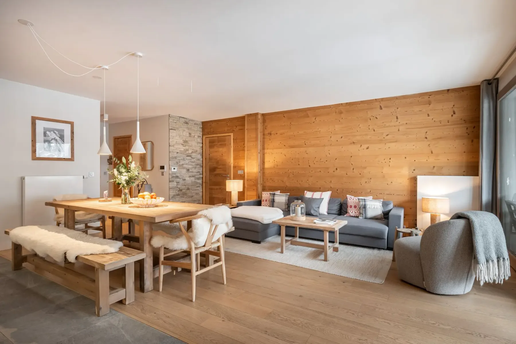 Un salón con una mesa de comedor, asientos y una pared revestida de madera.