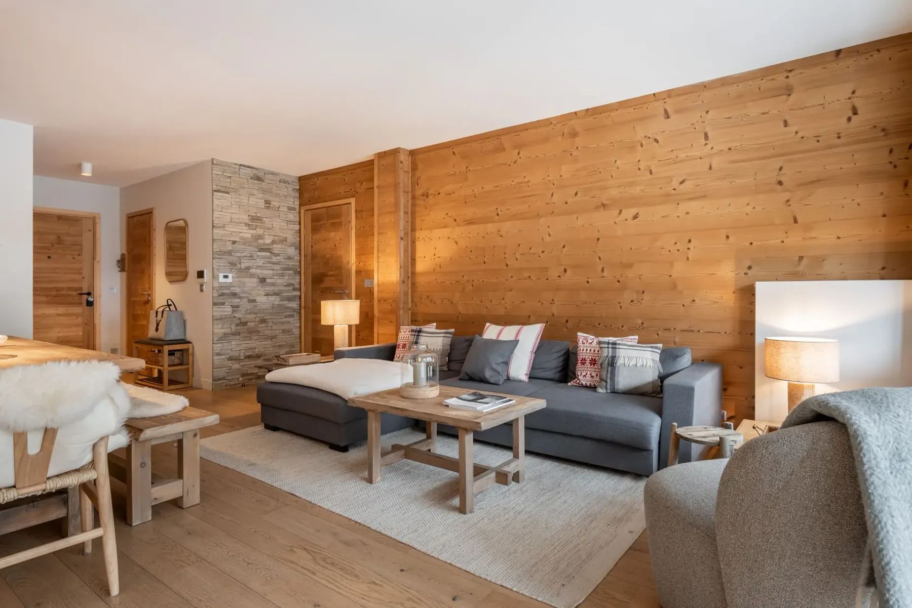 Un salón con asientos, una mesa de centro y paredes revestidas de madera.