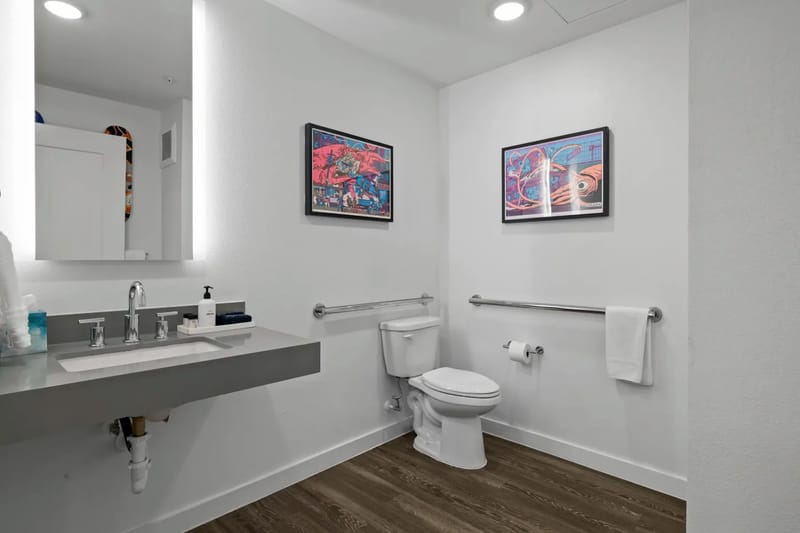 Baño con lavabo moderno, inodoro y toallero.