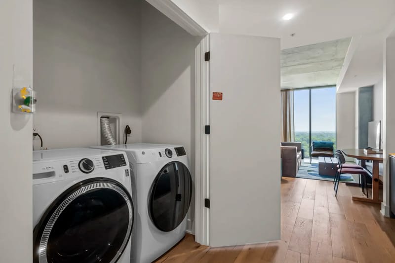 Área de lavandería con lavadora y secadora de carga frontal en un apartamento moderno.