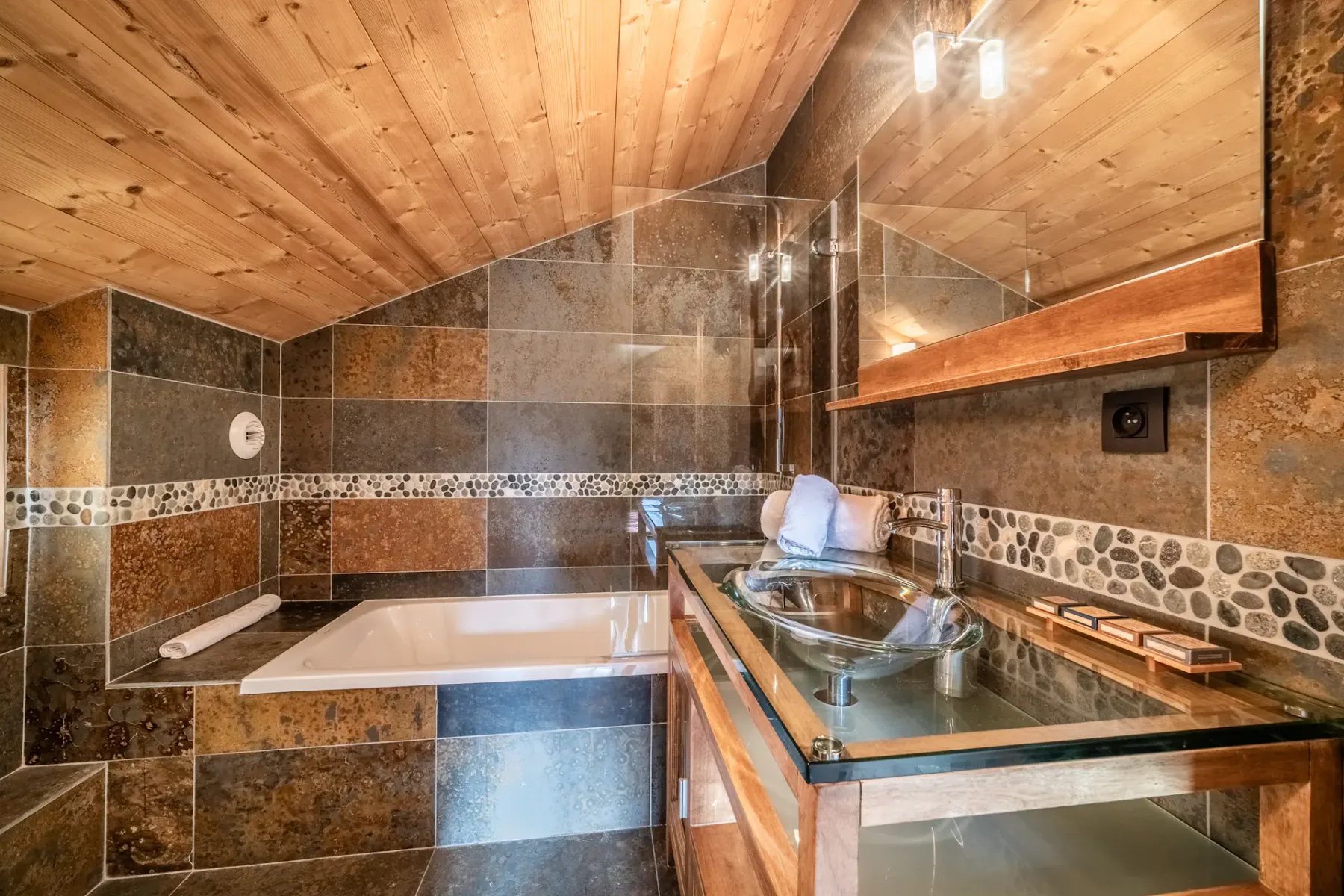 Un baño con suelo de madera y paredes alicatadas.
