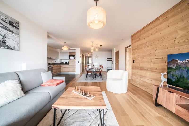 Sala de estar con interiores de madera, asientos y vistas a las montañas.