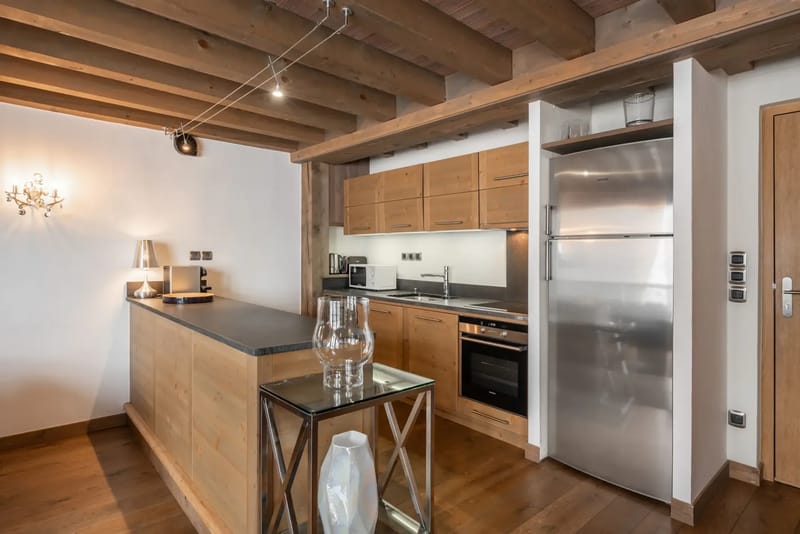 Cocina moderna con armarios de madera, electrodomésticos de acero inoxidable y una isla central.
