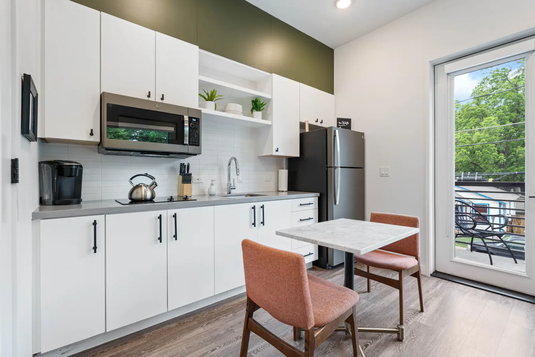 Cocina compacta con gabinetes blancos y encimera gris.