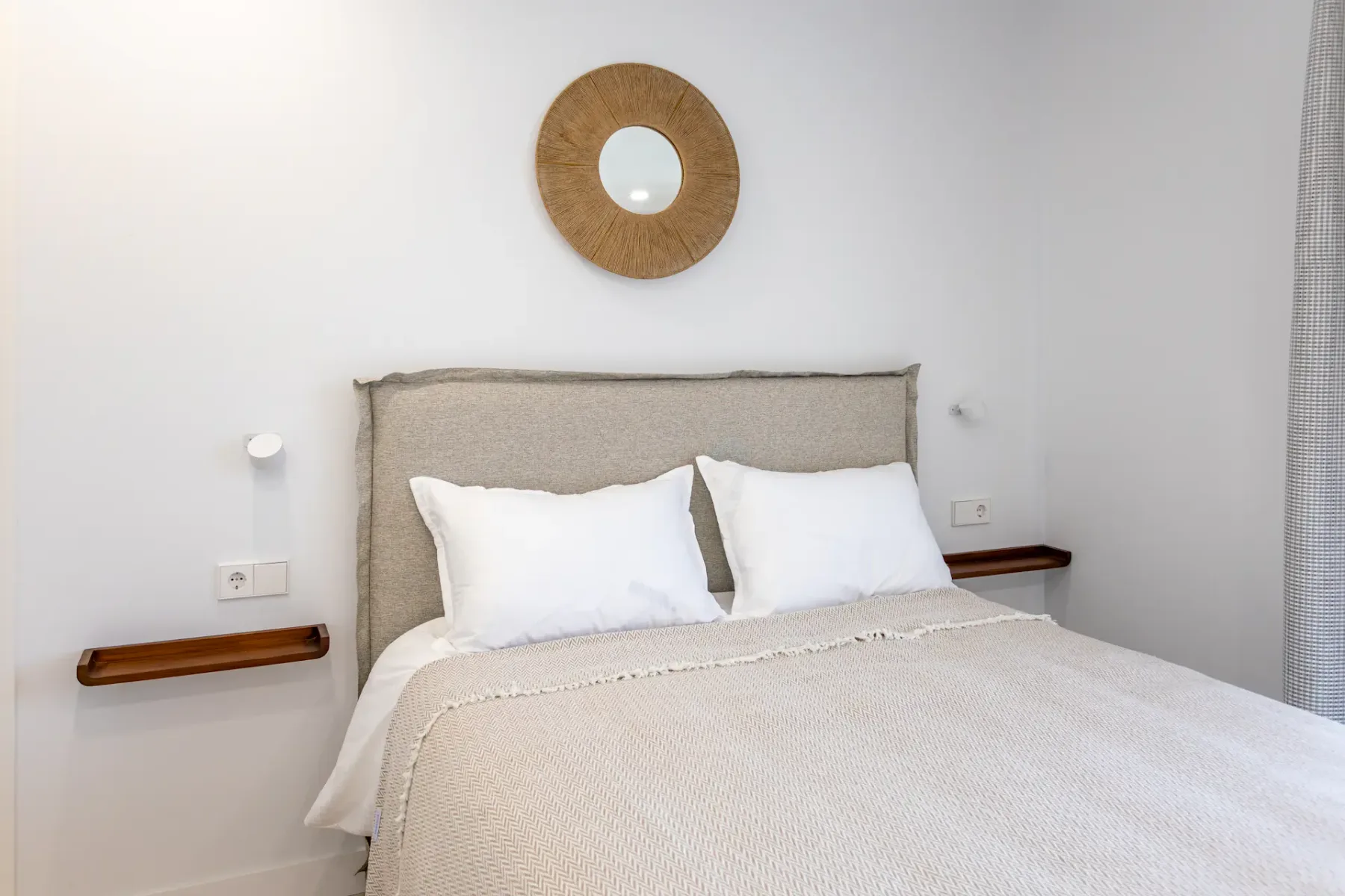 Bedroom with a neatly made bed and bright, minimal decor.