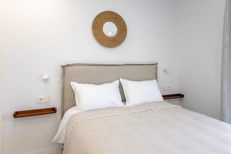 Bedroom with a neatly made bed and bright, minimal decor.