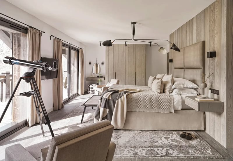 Dormitorio con una cama grande, telescopio, armario, televisión y zona de estar.