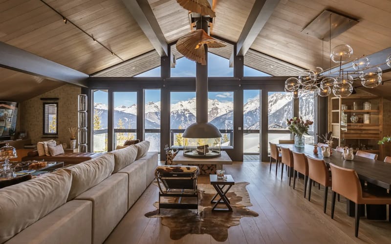 Living room with fireplace, dining area and mountain views.