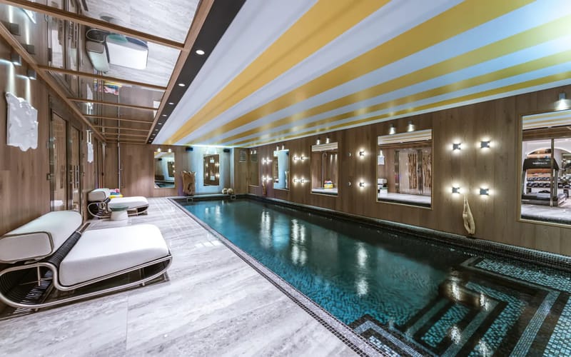 Indoor swimming pool with modern design and lounge seating.