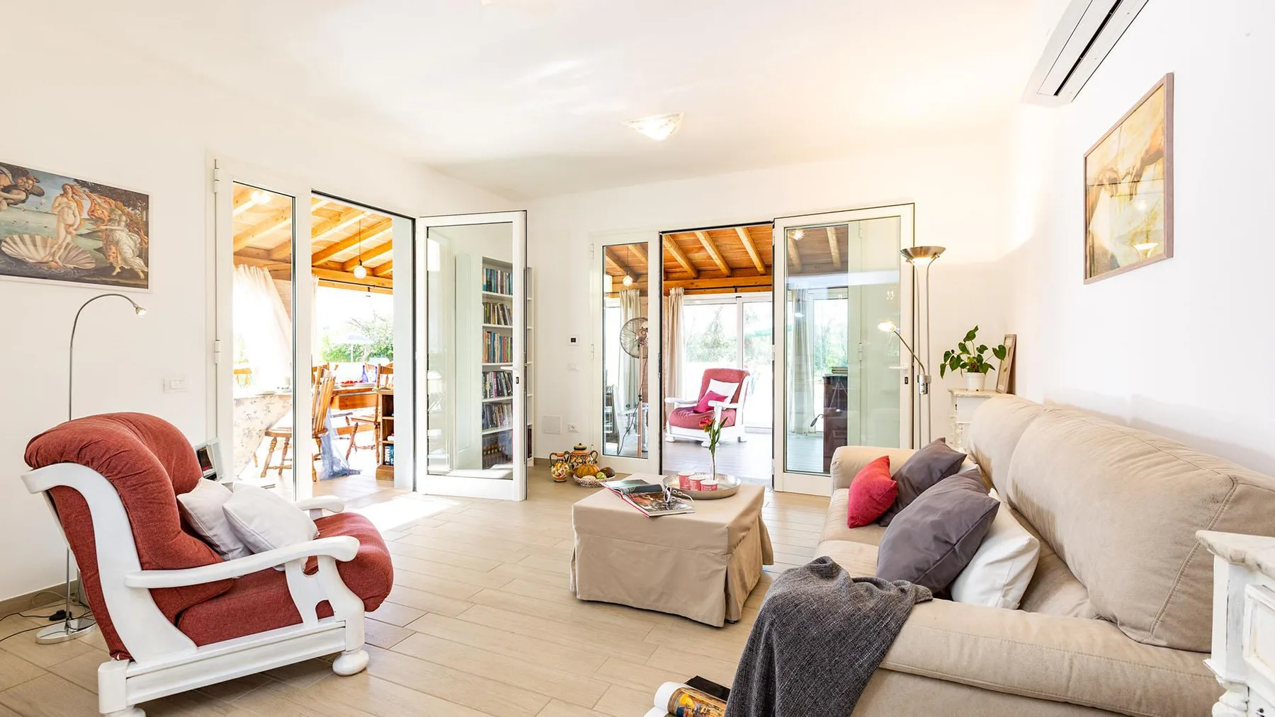 A bright living room opens through glass doors to a covered patio.
