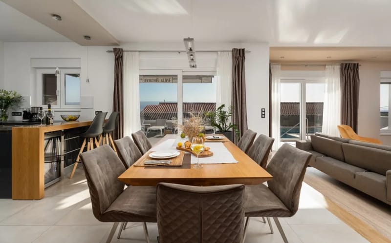 Mesa de comedor para 8 personas y cocina totalmente equipada conectada con la zona de la piscina