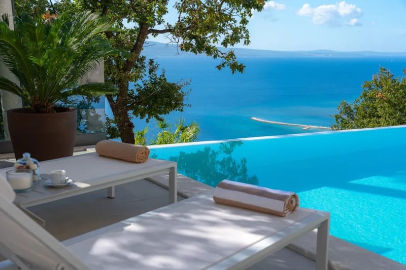 Piscina infinita privada climatizada con hidromasaje y amplio solárium.