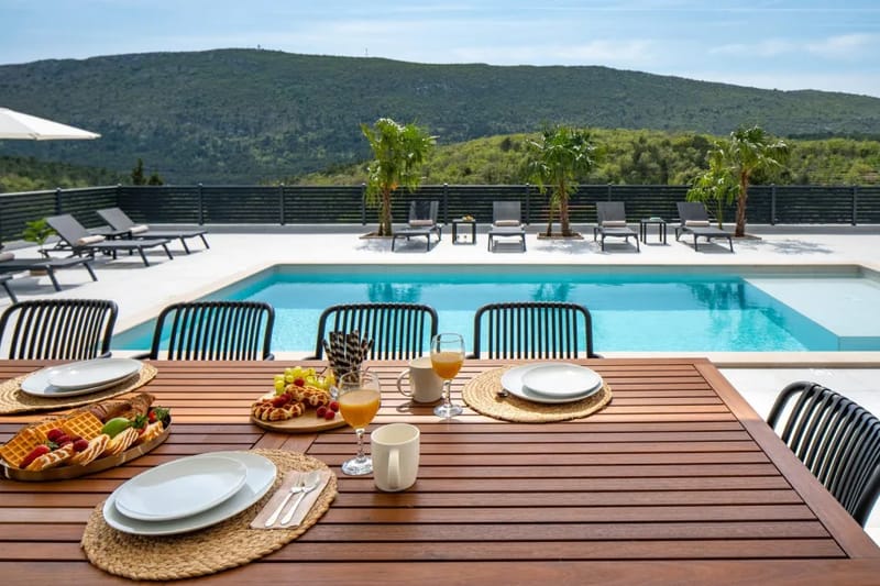 Mesa de comedor exterior cubierta con asientos para diez