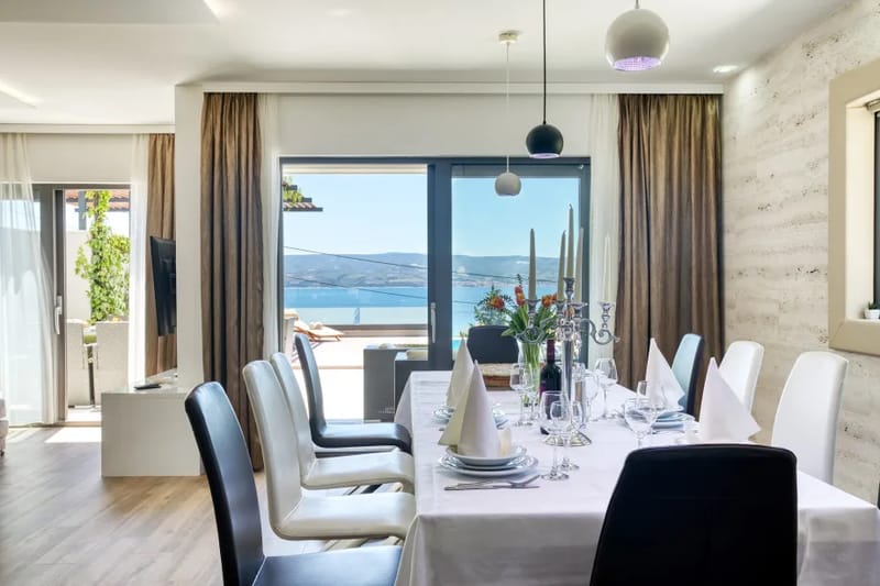 Zona de comedor para 12 personas con vistas despejadas a la piscina y al mar