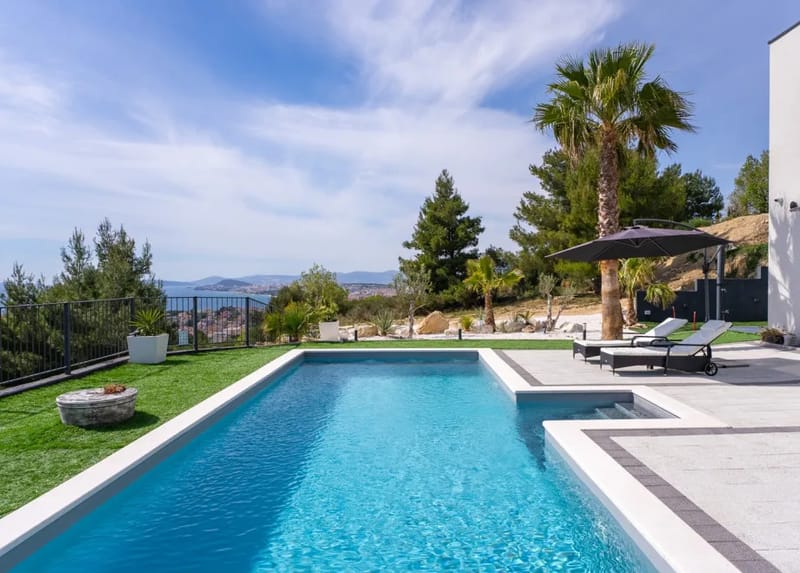 Private swimming pool with eight deck chairs