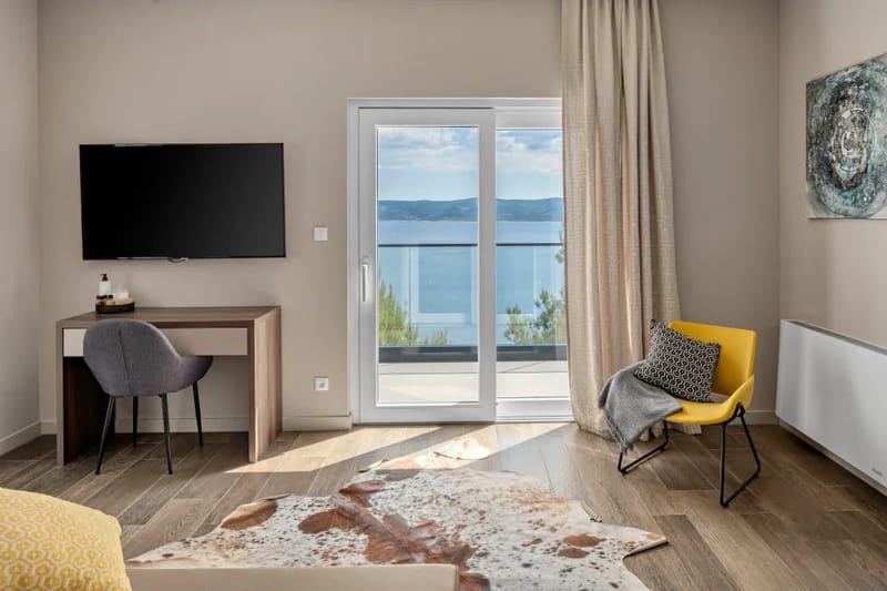 Dormitorio principal con cama king size, baño privado, TV, aire acondicionado y balcón
