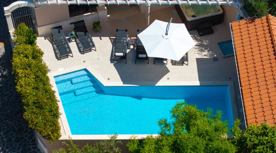 Piscina privada climatizada de 8 m x 3 m con hidromasaje y ducha exterior, y una zona para tomar el sol con 6 tumbonas