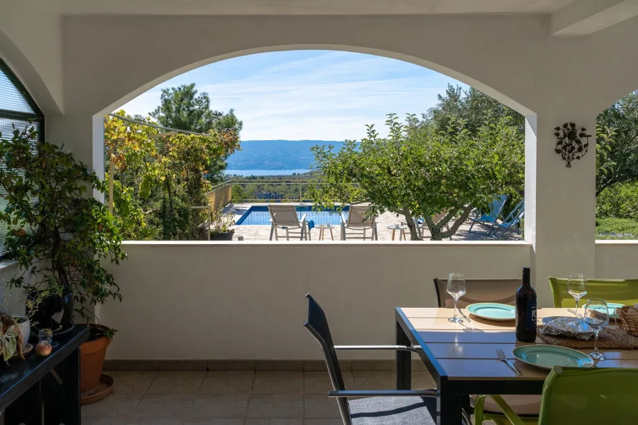 Una zona de comedor exterior cubierta para 8 personas con vistas panorámicas