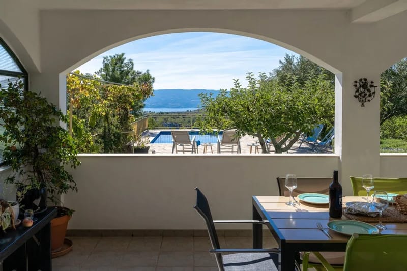 An outdoor covered dining area for 8 people with a panorama