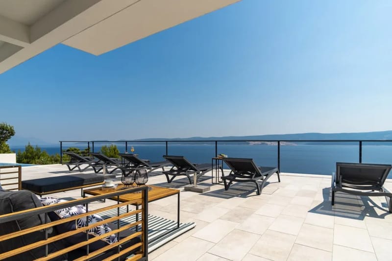 Terraza para tomar el sol con tumbonas, sombrillas, ducha exterior y mesa de ping-pong