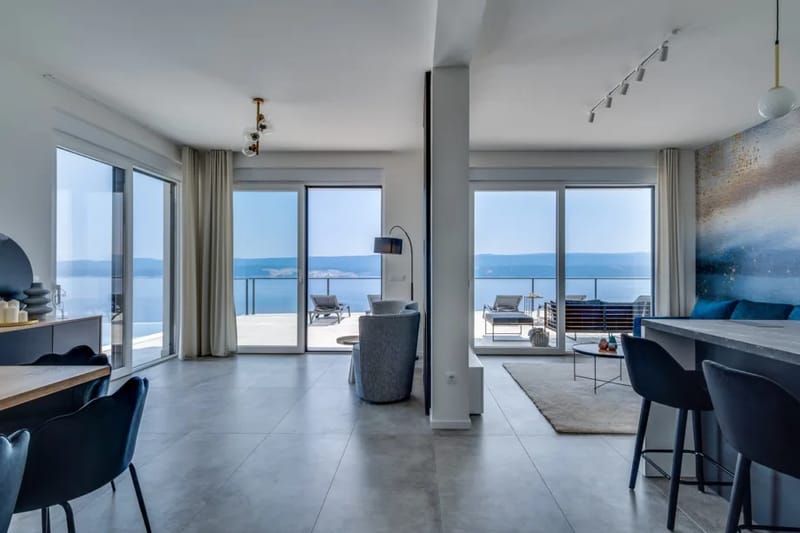 Zona de estar en la planta baja con televisión, aire acondicionado, Wi-Fi y puertas que dan a la zona de la piscina