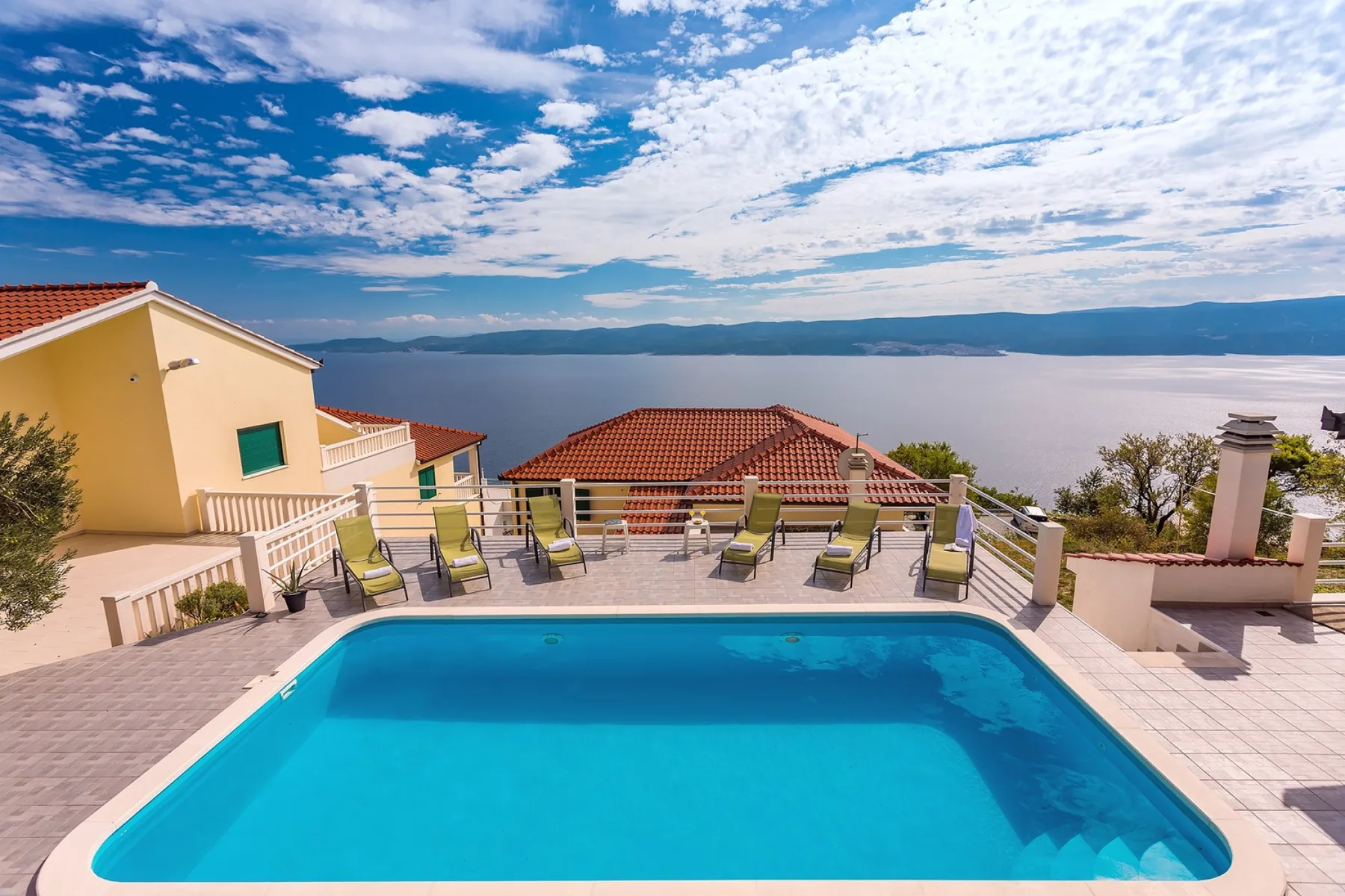 Una piscina y tumbonas ofrecen vistas al mar.