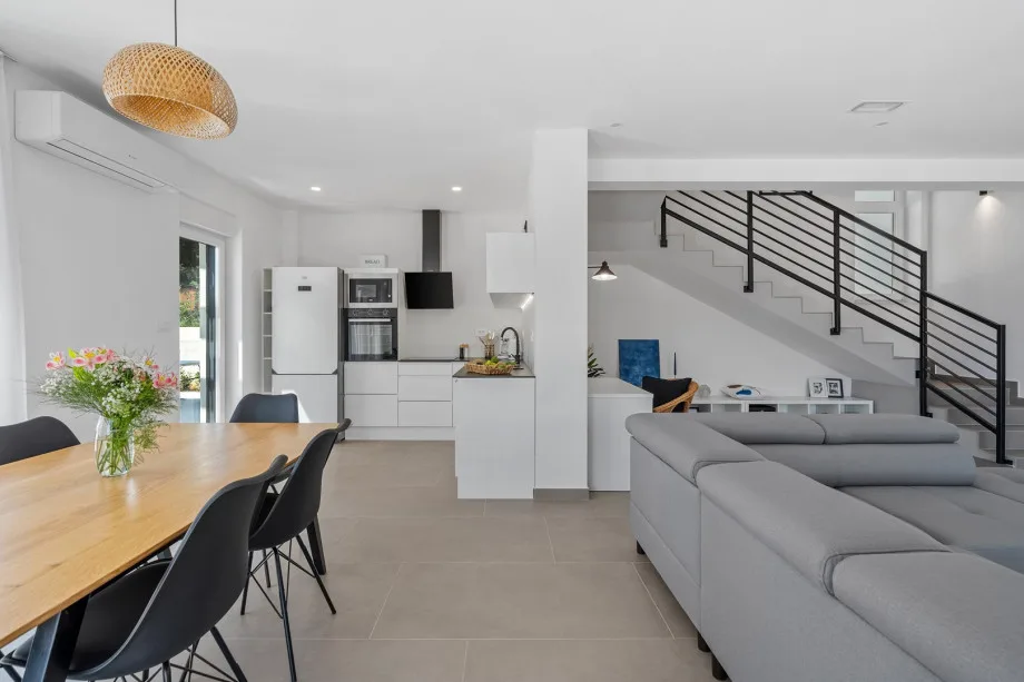 Living area with flat-screen TV, air conditioning and direct access to the outdoor dining area and pool