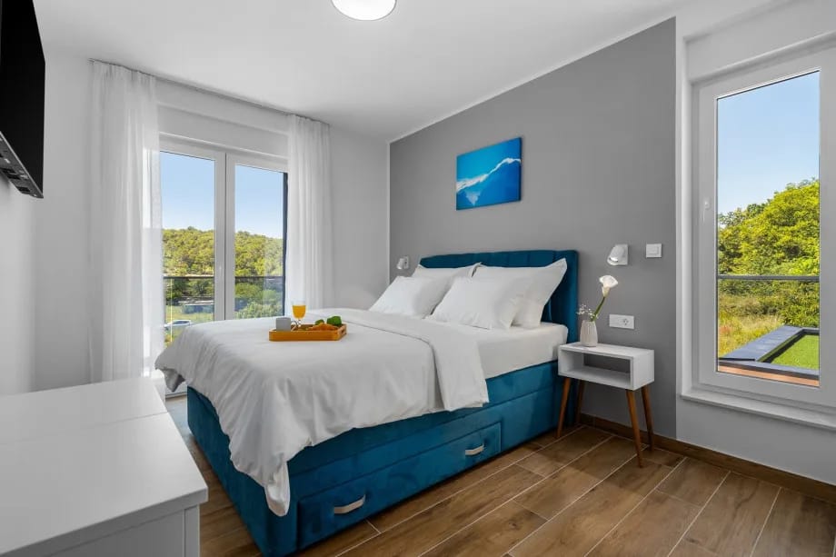 Bedroom 1 with queen-size bed, air conditioning, en-suite bathroom and balcony with pool views