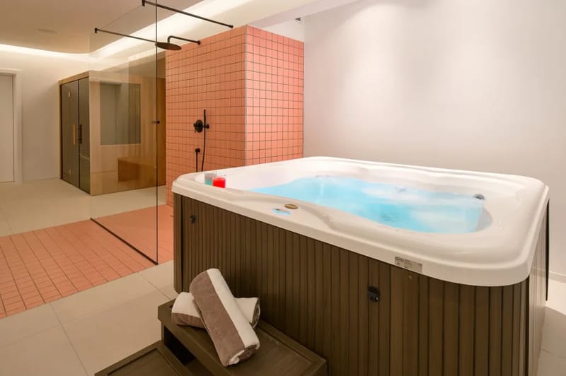 Sala de spa con sauna finlandesa y bañera de hidromasaje interior