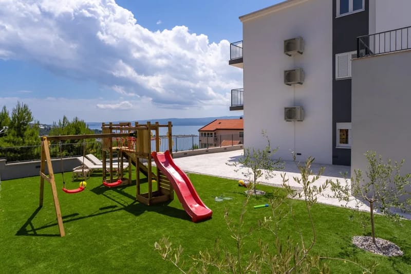 Sundeck with artificial grass, children's house, and slide