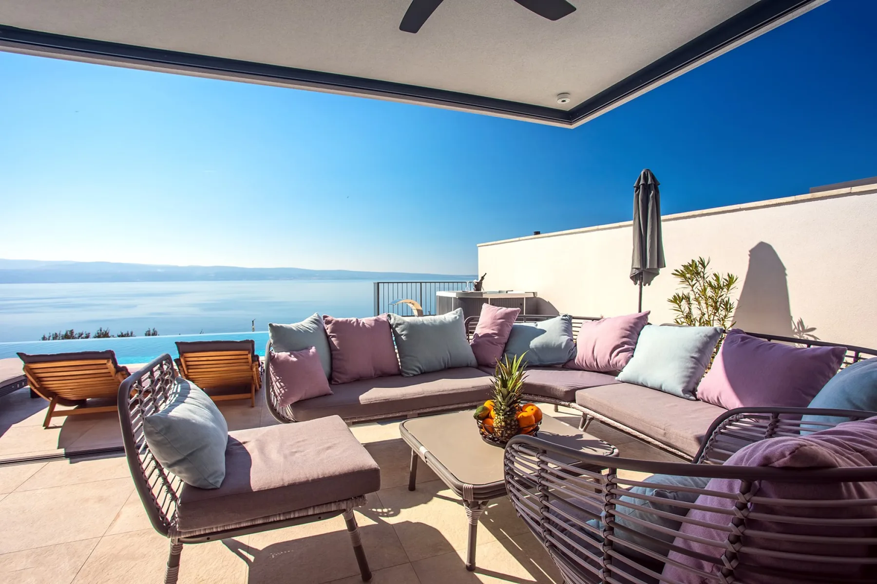 Covered lounge and outdoor dining area beside the pool